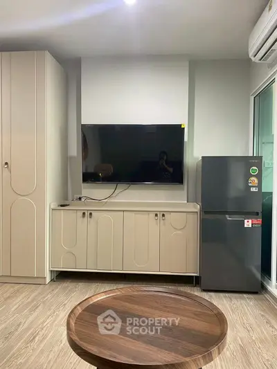 Modern living room with sleek TV setup and compact fridge