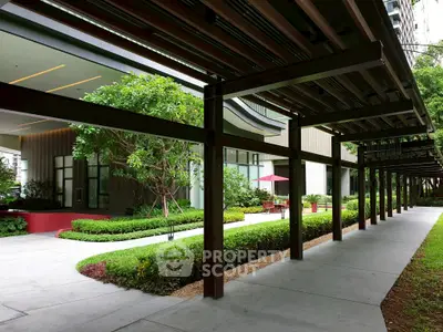 Modern building entrance with lush landscaping and covered walkway
