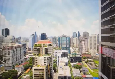 Stunning cityscape view from high-rise building with lush greenery and modern architecture.