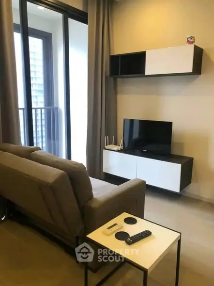 Modern living room with sleek furniture and balcony view in a stylish apartment.