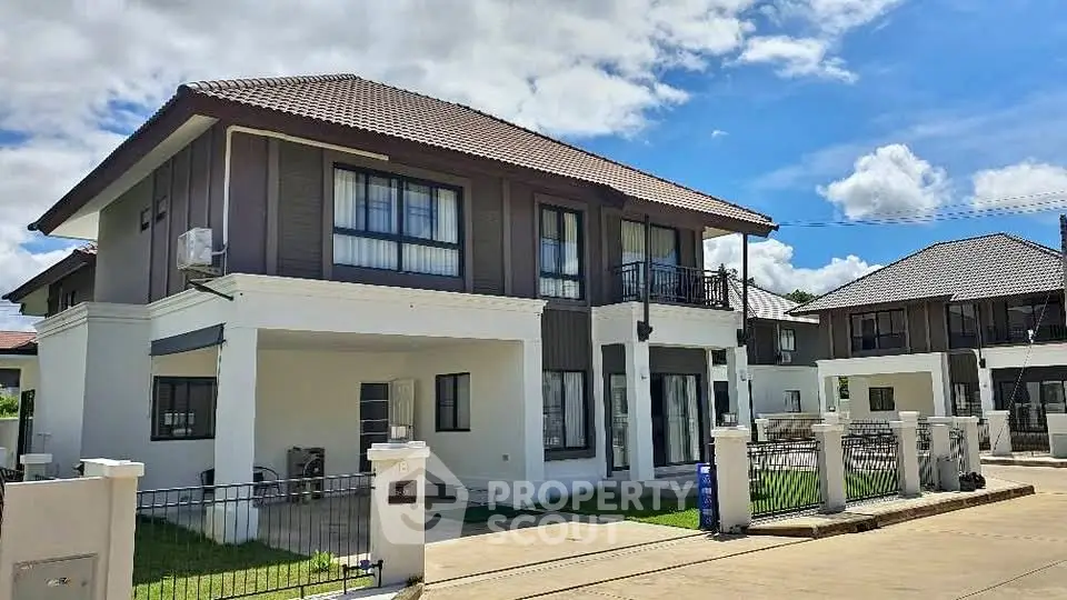 Modern two-story house with a tiled roof and manicured lawn in a suburban neighborhood.