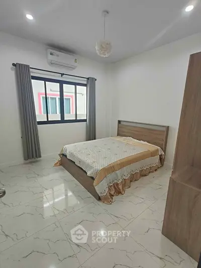 Spacious bedroom with modern decor and natural light, featuring a comfortable bed and elegant curtains.