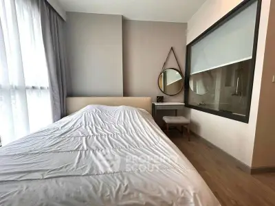 Modern bedroom with large window and stylish decor in a contemporary apartment.
