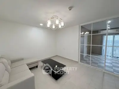 Spacious modern living room with elegant lighting and large windows.