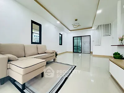 Spacious modern living room with elegant beige sofa and sleek tile flooring.