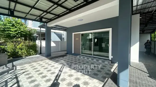 Modern covered entrance with stylish tile flooring and glass doors