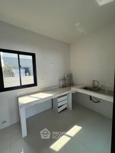 Minimalist kitchen with sleek countertops and modern sink in bright natural light.