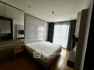 Spacious bedroom with modern decor and large window offering ample natural light.