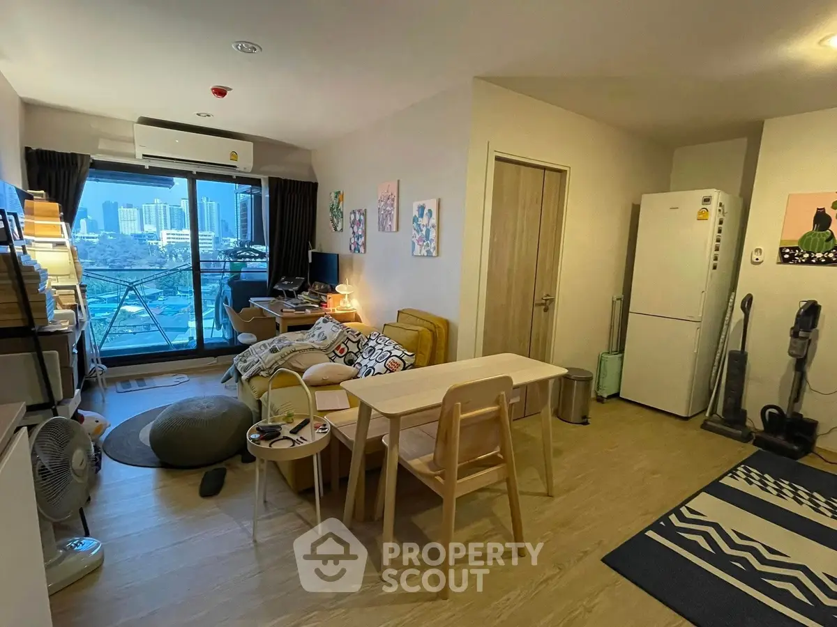 Modern living room with city view, cozy seating, and stylish decor in a high-rise apartment.