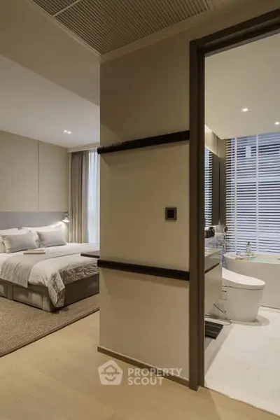 Modern bedroom with ensuite bathroom featuring elegant design and neutral tones.