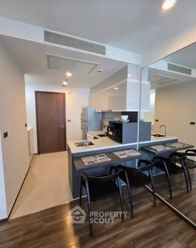 Modern kitchen with sleek design and bar seating in a stylish apartment.