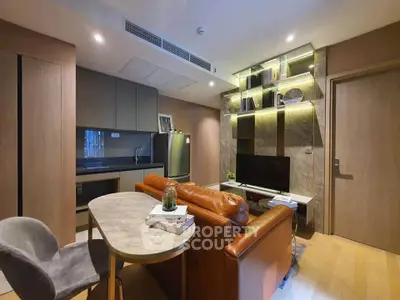 Modern living room with open kitchen, stylish lighting, and cozy seating area in a contemporary apartment.