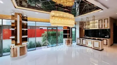 Luxurious modern living room with elegant chandelier and floor-to-ceiling windows.