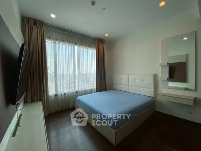 Spacious bedroom with city view, modern furnishings, and natural light.