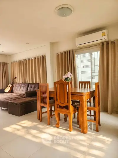 Spacious living room with elegant dining set and cozy sofa, enhanced by natural light and modern decor.