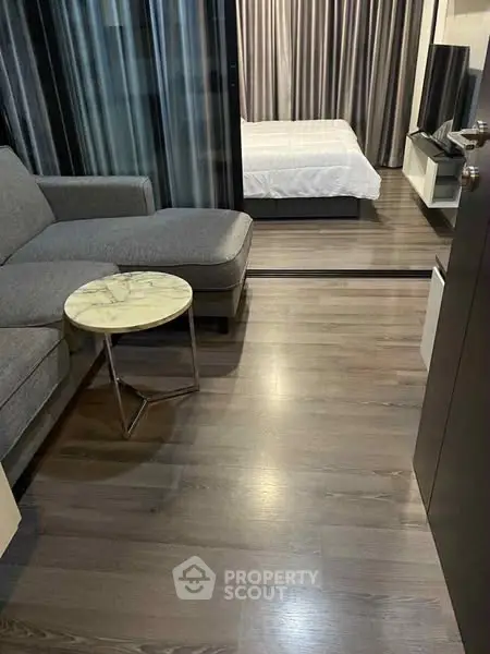 Modern studio apartment with sleek wooden flooring and cozy furnishings.