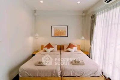 Cozy bedroom with twin beds and soft lighting, ideal for relaxation.