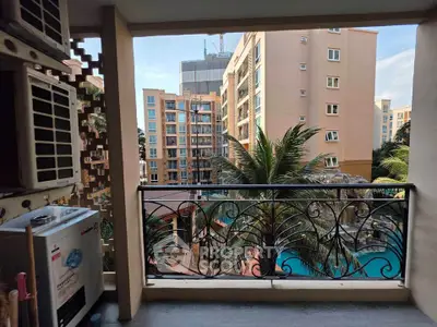 Charming balcony view overlooking a pool and modern apartment buildings, perfect for relaxation and urban living.