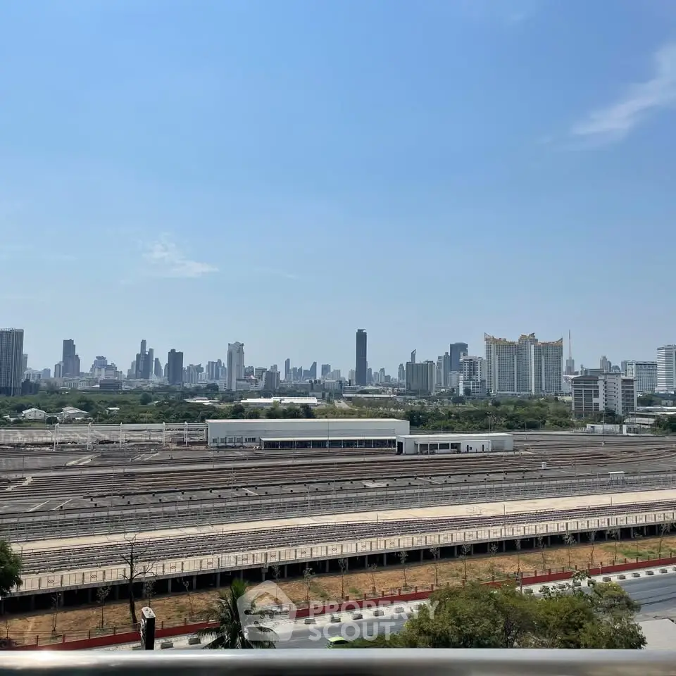 Stunning cityscape view from a high-rise building, showcasing urban skyline and railway tracks.
