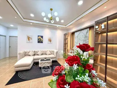 Luxurious living room with elegant decor and modern lighting, featuring a plush sectional sofa and stylish shelving.