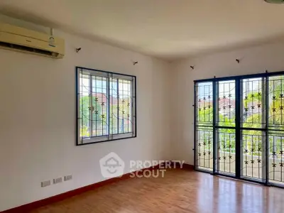 Spacious room with large windows and air conditioning, perfect for natural light and comfort.