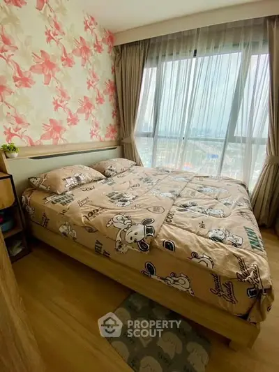 Cozy bedroom with floral wallpaper and large window offering city views, perfect for relaxation.