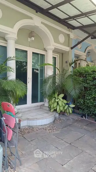 Charming entrance with lush greenery and elegant columns, perfect for a welcoming home ambiance.