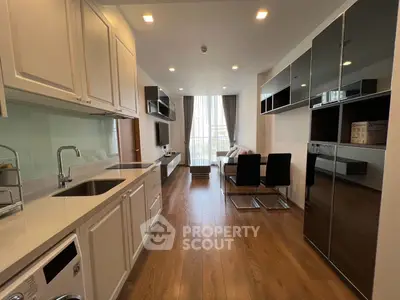 Modern kitchen with sleek design and open layout, featuring hardwood floors and stylish dining area.