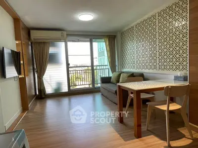 Modern living room with stylish decor and balcony view, featuring wooden flooring and elegant partition.