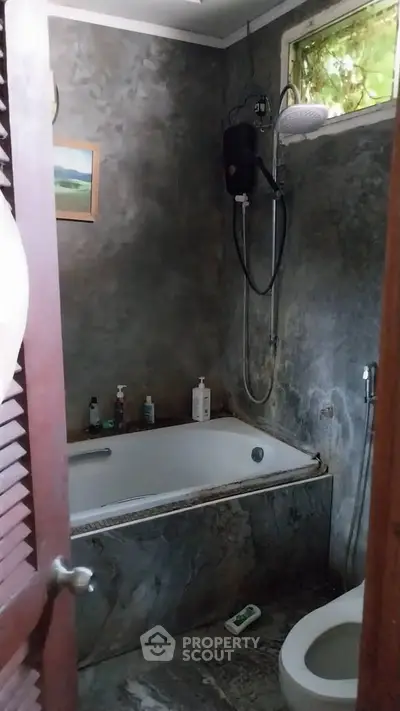 Cozy bathroom with bathtub and modern shower in rustic stone design