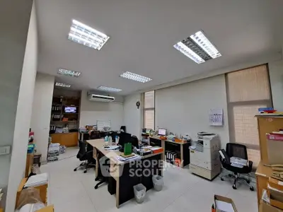 Spacious office with modern lighting and organized workstations, ideal for productivity and collaboration.