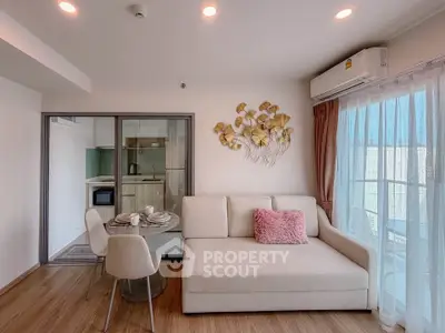 Modern living room with cozy sofa, dining area, and stylish decor in a bright apartment.