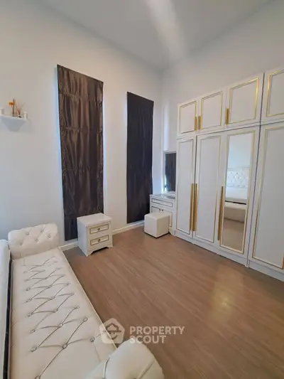 Luxurious bedroom with elegant white furniture and mirrored wardrobe doors