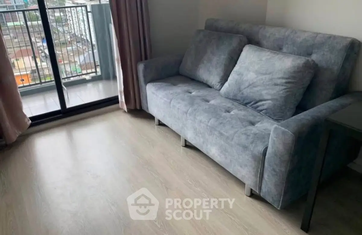 Cozy living room with modern gray sofa and balcony view