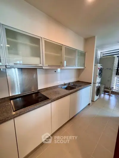 Modern kitchen with sleek cabinets and built-in appliances in a stylish apartment.