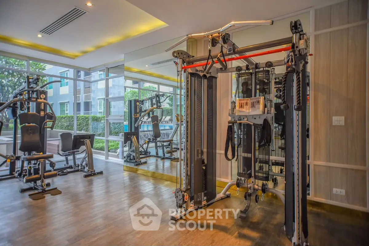Modern gym with state-of-the-art fitness equipment and mirrored walls in luxury apartment complex.