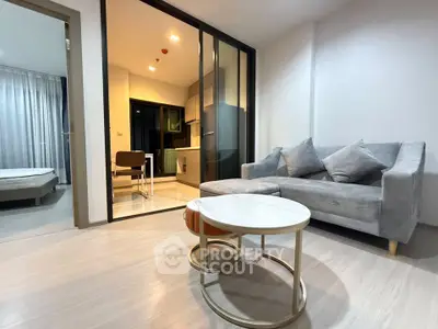 Modern living room with sleek furniture and open kitchen layout in a stylish apartment.