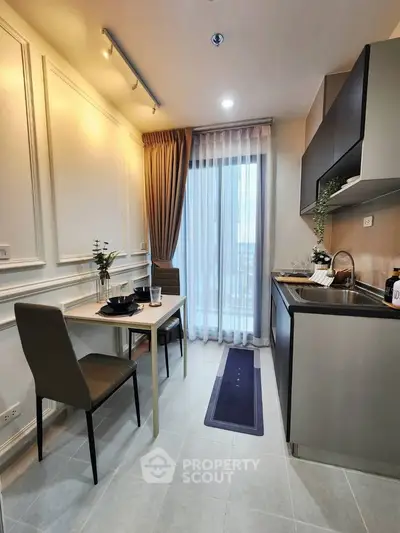 Modern kitchen with sleek cabinetry and dining area in stylish apartment