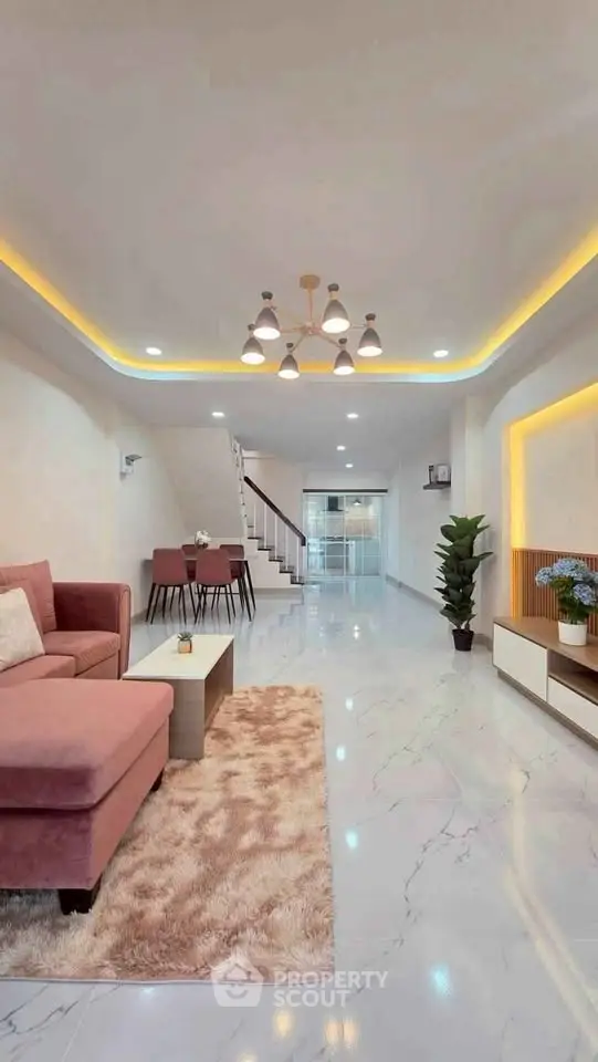 Spacious modern living room with elegant lighting and plush pink sofa, perfect for stylish living.