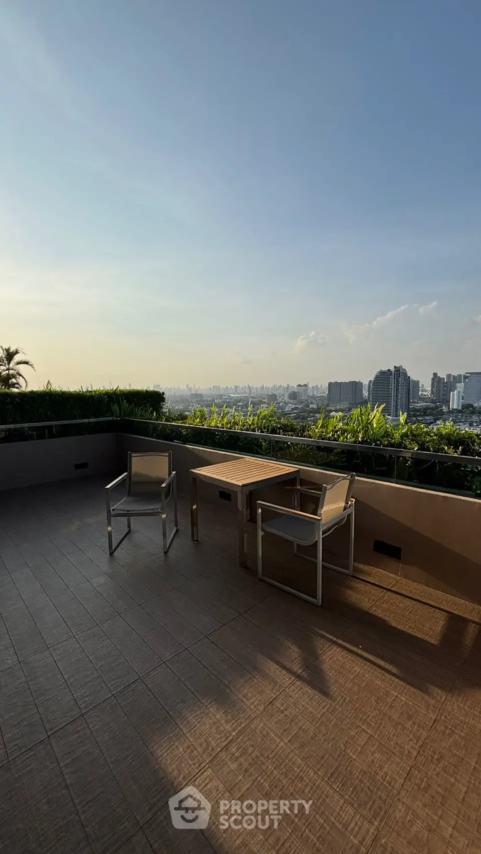 Spacious rooftop terrace with stunning city skyline view and modern outdoor furniture.