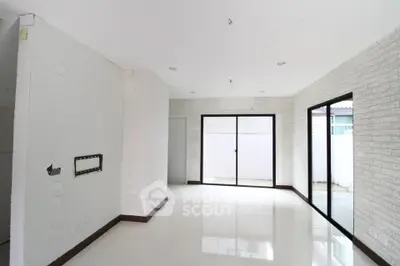 Spacious modern living room with large windows and white brick walls