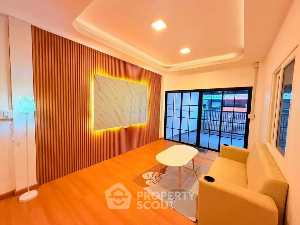 Modern living room with stylish lighting and wooden accent wall, featuring a cozy sofa and coffee table.