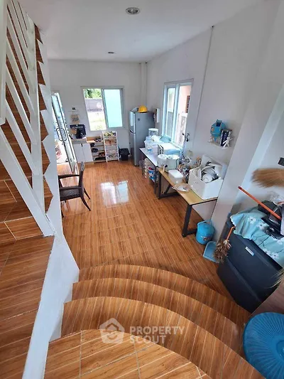 Spacious kitchen with wooden flooring and modern appliances, perfect for culinary enthusiasts.