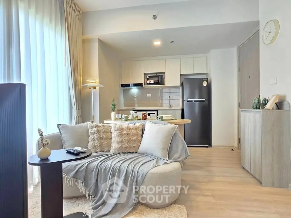 Modern open-plan living room with cozy seating and stylish kitchen area, perfect for urban living.