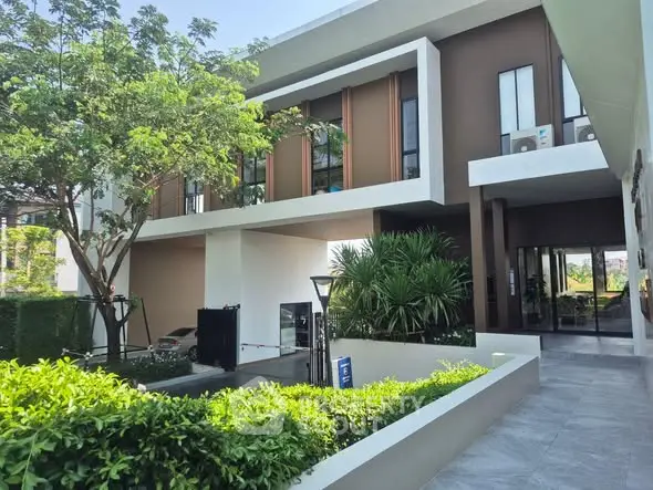 Modern residential building with lush greenery and sleek architectural design.