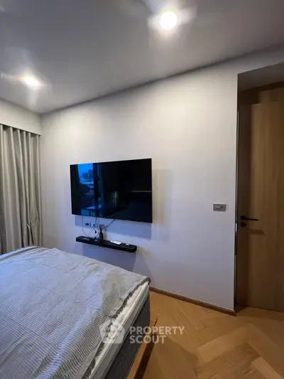 Modern bedroom with wall-mounted TV and stylish decor