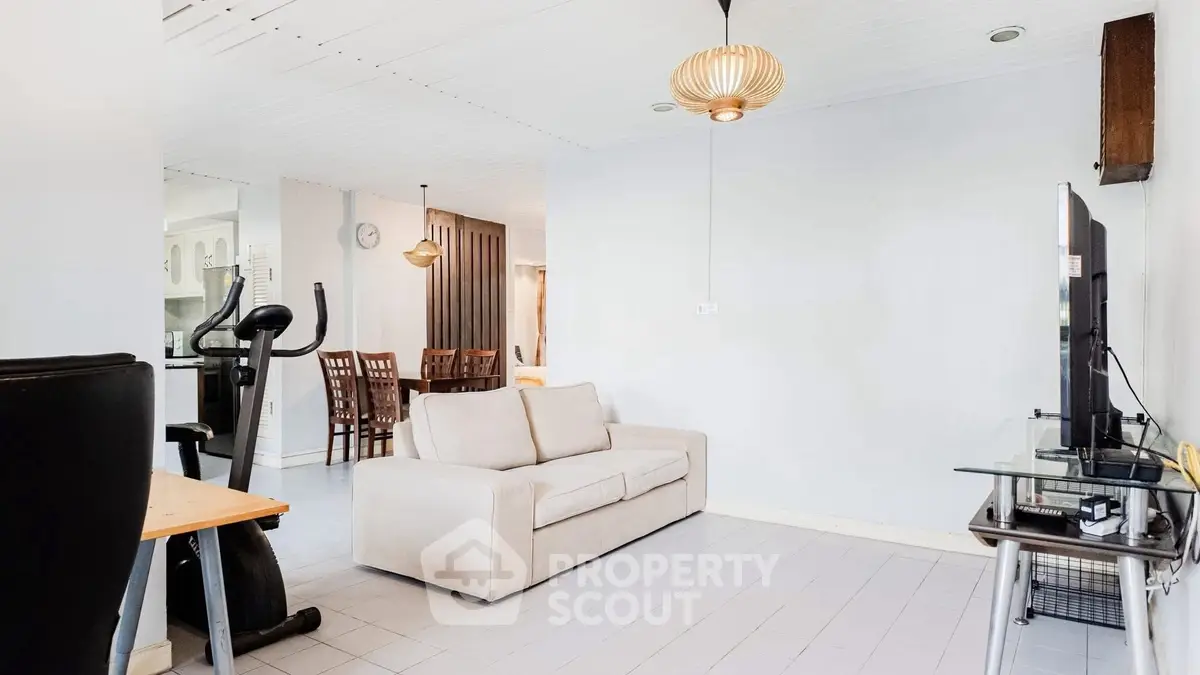 Spacious living room with modern decor and exercise equipment, perfect for relaxation and fitness.