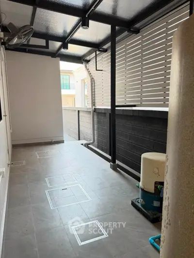 Modern covered outdoor space with sleek design and privacy screen, perfect for relaxation or utility use.