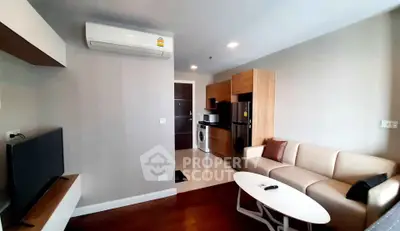 Modern living room with integrated kitchen featuring sleek appliances and stylish furniture