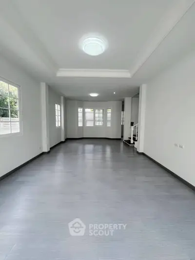 Spacious empty living room with large windows and modern flooring
